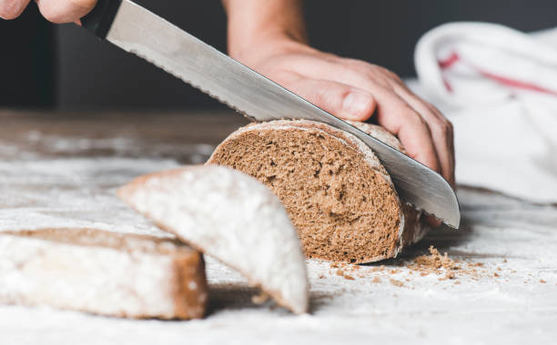 istock Woman Cutting Bread 1308941883