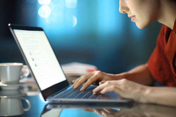 mulher verificando tela do laptop na noite em casa - surfar na net - fotografias e filmes do acervo