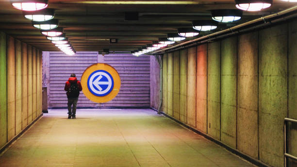 Man walking out of Prefontaine Metro station in Montreal Man walking out of Prefontaine Metro station in Montreal. A large arrow sign shows the direction to the exit. montreal underground city stock pictures, royalty-free photos & images