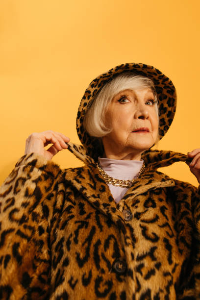 istock Woman wearing leopard fur coat adjusting her collar while standing at studio 1308942119