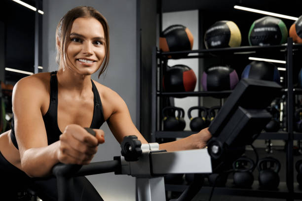 istock Smiling young woman engaged on exercise bike. 1308942143
