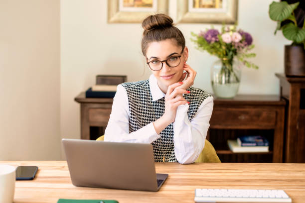 istock Smiling young businesswoman using her laptop while working from home 1308942639