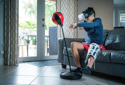 Teen with injured leg doing Virtual reality boxing