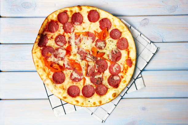 istock Pepperoni pizza with salami and mozzarella on wooden table. 1308946066