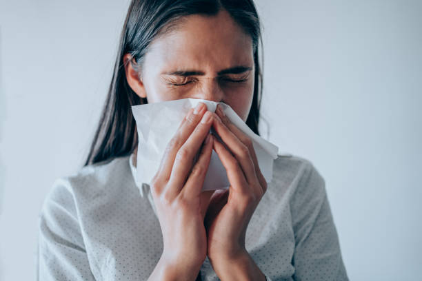 istock Young woman blowing her nose. 1308948064