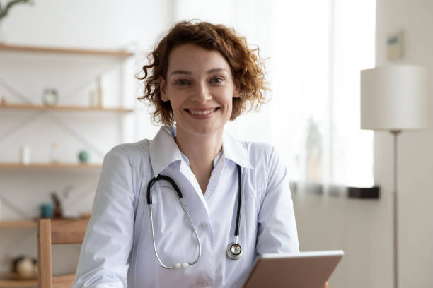 istock Portrait of smiling female GP use tablet 1308949165