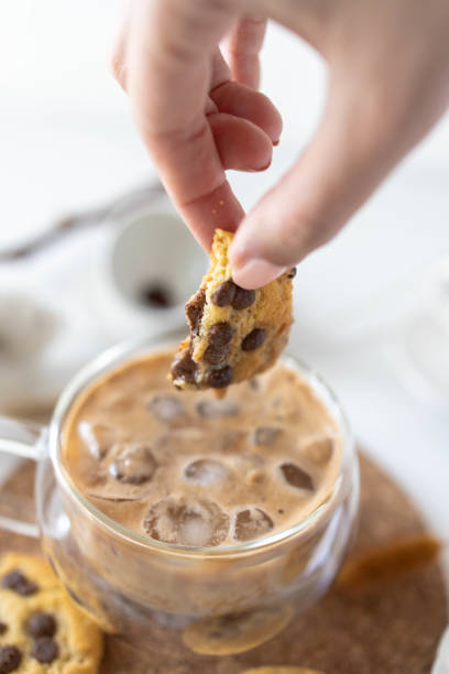 istock woman's hands dipping cookie in coffee 1308950505