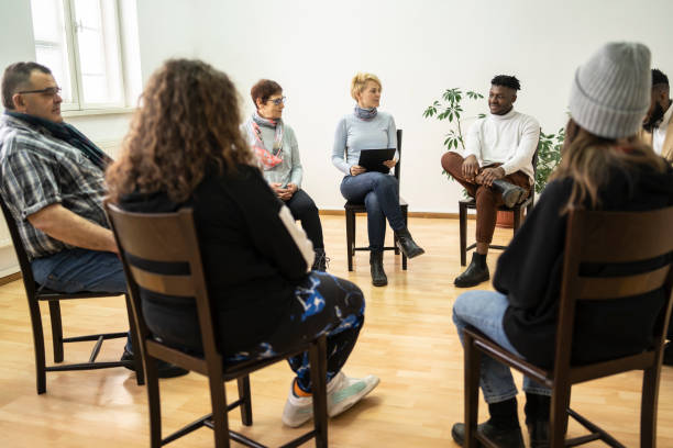 Group therapy support meeting talking about their mental health Group therapy support meeting talking about their mental health in a modern mental health facility recovery photos stock pictures, royalty-free photos & images