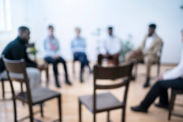 Meeting of mental health support group - defocused Meeting of support group sitting in a circle - defocused in a modern mental health facility alcoholics anonymous photos stock pictures, royalty-free photos & images