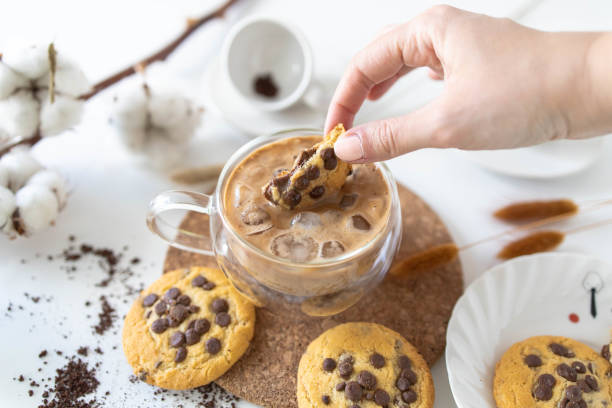 woman's hands dipping cookie in coffee woman's hands dipping cookie in coffee chocolate chip cookie top view stock pictures, royalty-free photos & images