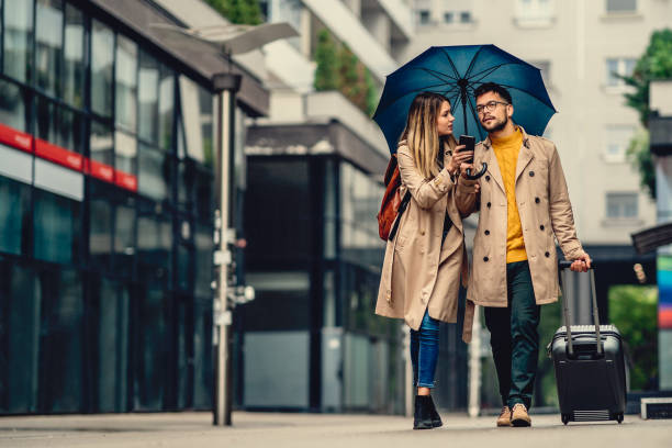 istock beautiful young couple walking in the rain 1308951873