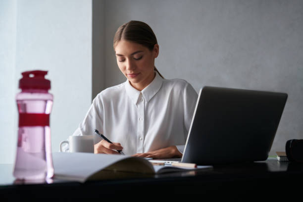 istock Concentrated woman working on laptop while staying at home 1308951880