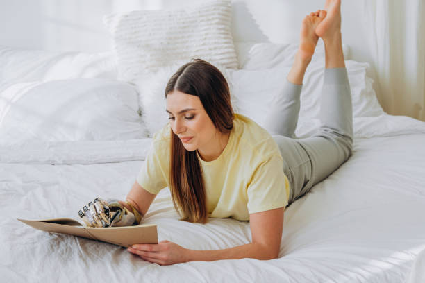 istock Woman writes in paper notebook with bionic arm lying on bed 1308953003