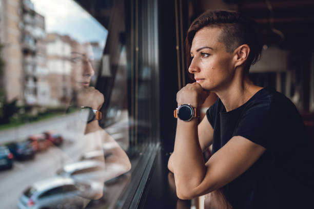 A woman in a black T-shirt sitting in a cafe by the window A woman in a black T-shirt sitting in a cafe by the window half shaved hairstyle stock pictures, royalty-free photos & images