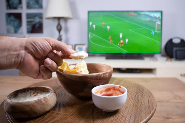 집에서 칩을 먹고 tv를 보는 - appetizer bowl potato chip condiment 뉴스 사진 이미지