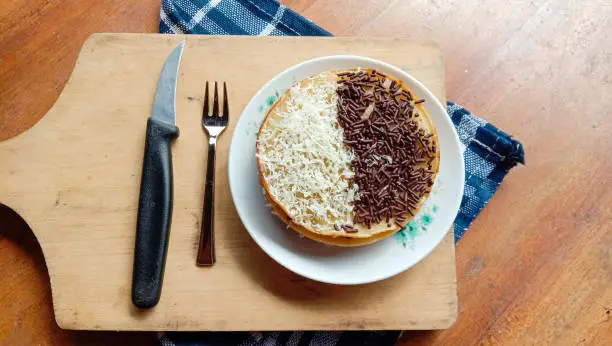 mini martabak with a sprinkling of grated cheese and sprinkles, a cup of tea on the table