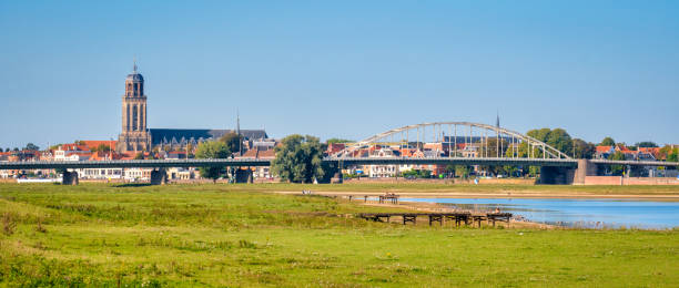 River IJssel and the Dutch Hanze city of Deventer (Netherlands) Dutch panorama landschape near the Hanze city of Deventer. The famous Wilhelmina Bridge and Great Church or St. Lebuinus Church can also be seen. It is a warm and clear summer September day. ijssel stock pictures, royalty-free photos & images