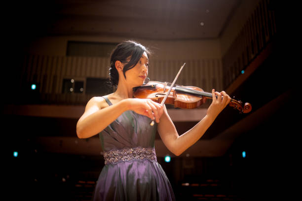 Woman playing violin at classical music concert Japanese musicians playing violin, viola, cello, and piano, and singing songs at classical music concert. classical concert photos stock pictures, royalty-free photos & images