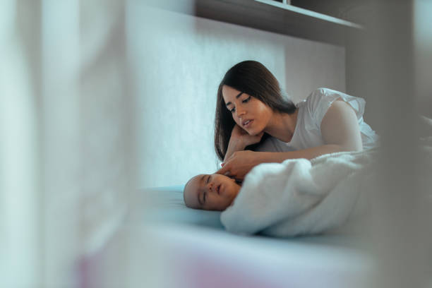 istock Caring mother looking at her baby sleeping 1308959533