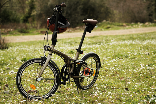 Izmir, Turkey - March 13, 2021: Btwin brand tilt 900 Foldable bicycle in meadow editorial image.