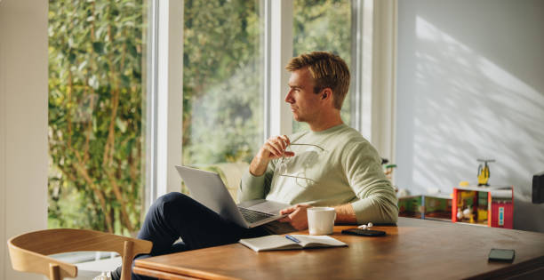 istock Thoughtful man with laptop at home 1308961753
