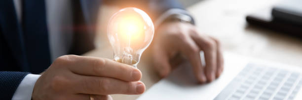 Horizontal banner close up businessman holding light bulb, inspiration concept