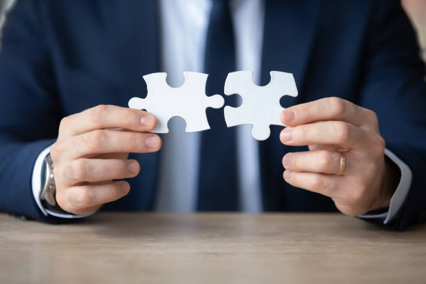 istock Close up businessman holding assembling jigsaw pieces, business solution 1308963300