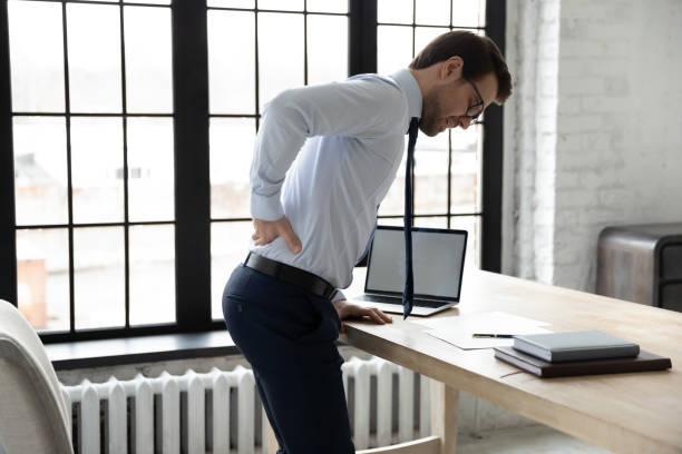 istock Unhealthy businessman touching lower back, suffering from backache in office 1308963305