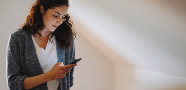 istock Woman at home texting on her phone 1308963326