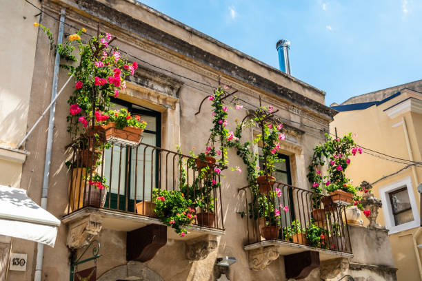 Typical Sicilian balcony in Taormina full of flowers and decorations Typical Sicilian balcony of historical buildings in the city centre of Taormina, full of flowers and decorations. sicily photos stock pictures, royalty-free photos & images