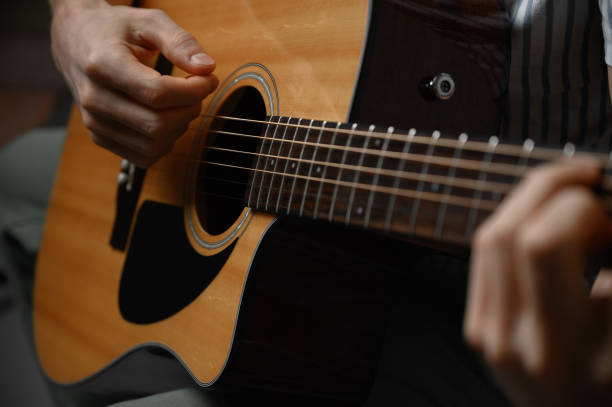 istock Man playing acoustic guitar, cover for online courses, learning at home. 1308965190