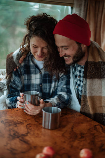 istock Couple sitting at a table in a motorhome and drinking tea. 1308966539