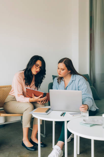 istock Two Young Businesswomen Working Together by Using a Laptop Computer 1308967939