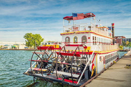 A paddle wheel boat, used for boat cruises, is docked in Erie, Pennsylvania USA on a sunny day.