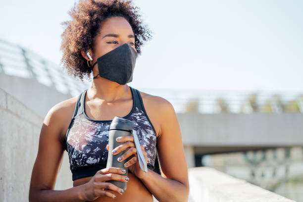 istock Athletic woman drinking water after work out outdoors. 1308968585
