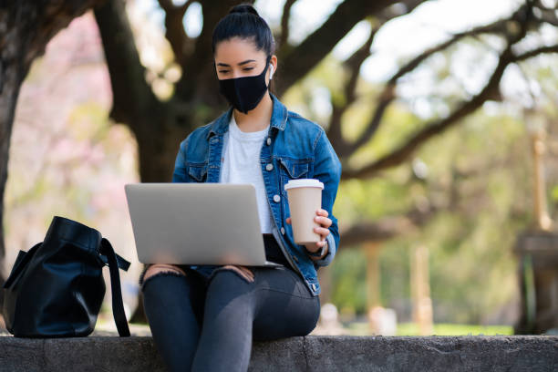 istock Young woman using her laptop outdoors. 1308968608