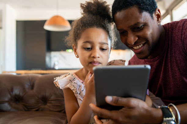 istock Father and daughter using digital tablet at home. 1308968654