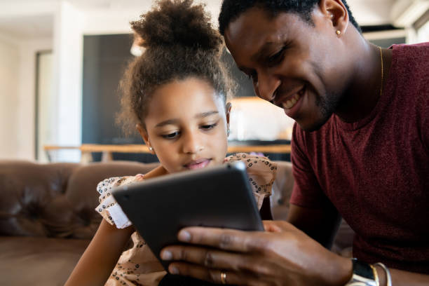 istock Father and daughter using digital tablet at home. 1308968663