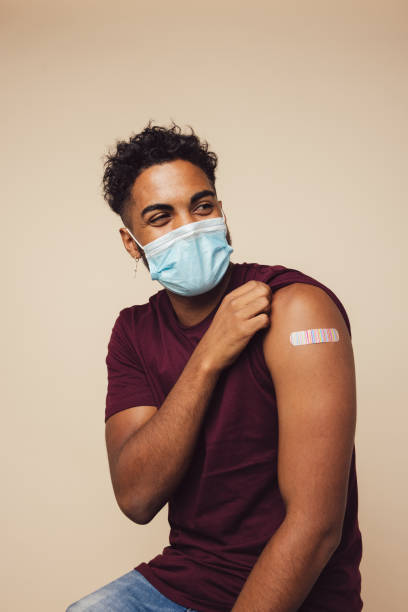 istock Man wearing face mask showing his vaccinated arm 1308969079