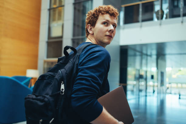 étudiant d’université allant à la classe - regarder par dessus son épaule photos et images de collection