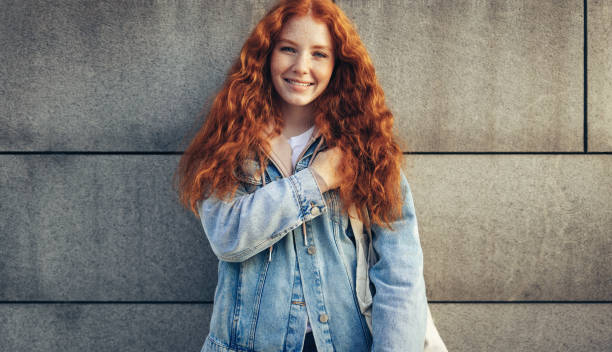istock College girl standing at wall 1308971365