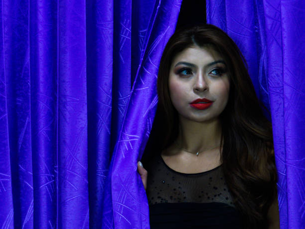 Elegant beautiful woman posing in curtain