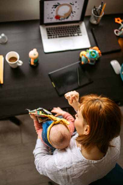istock Young mother trying to work while carrying baby 1308975362