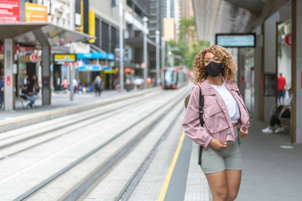istock Gorgeous mixed race woman wearing protective face mask while commuting in city 1308981744