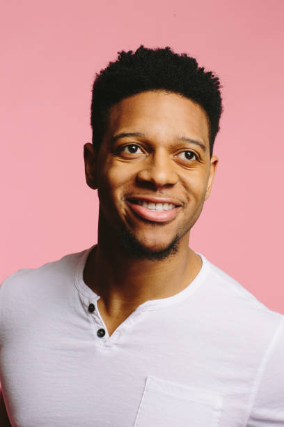 istock Happy young man smiling and looking upwards off camera, isolated  on pink 1308981869