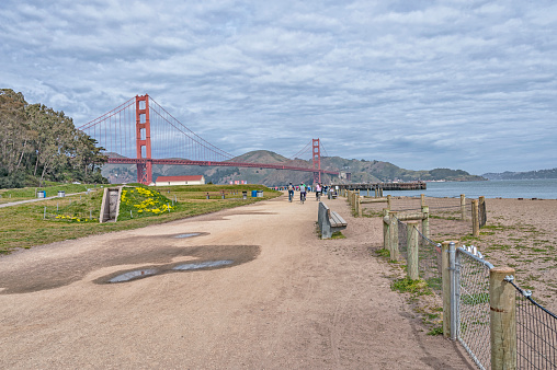 San Francisco, California - USA: This view of the Golden Gate Bridge is from the beach and Park along the shore line, this park and view is very popular especially in great weather like this March day under a cloudy sky because the view is always great to enjoy.