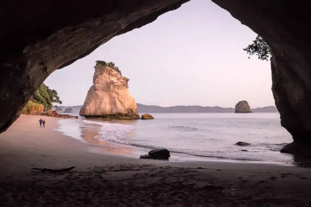 Photo of Tourists walking on beach in morning at Cathedral Cove, Coromandel Peninsula, New Zealand