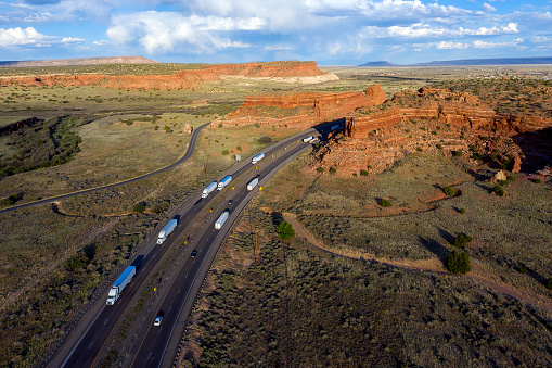 Landscape with red rocks and a highway with a truck traffic, New Mexico, USA, aerial view.