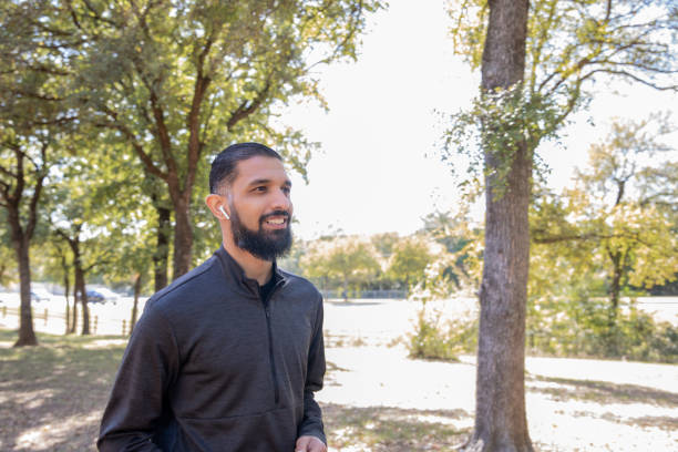 istock Young Middle Eastern man smiles during morning jog through a wooded park 1308983710