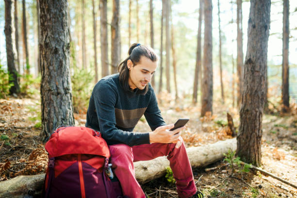 istock Young smiling man using a smart phone in the nature. 1308984057